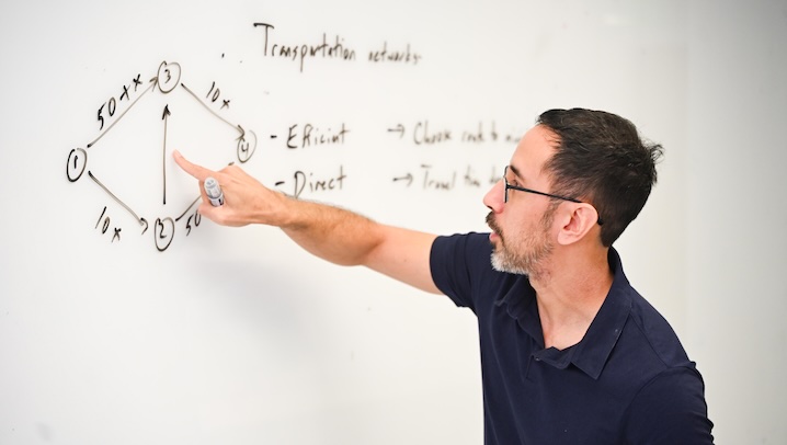 Professor pointing at an image drawn on a whiteboard